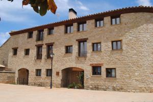 a large brick building with a large door at Apartamentos Turísticos Mallos de Huesca in Ayerbe