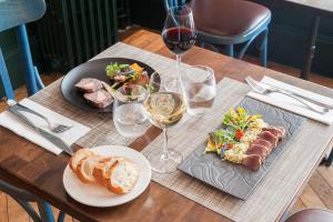 una mesa con platos de comida y copas de vino en The Originals Boutique, Hôtel Ô Gayot, Bagnoles-de-l'Orne (Inter-Hotel), en Bagnoles de l'Orne