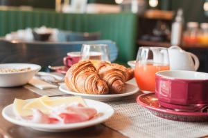 una mesa con platos de repostería y bebidas. en The Originals Boutique, Hôtel Ô Gayot, Bagnoles-de-l'Orne (Inter-Hotel), en Bagnoles de l'Orne