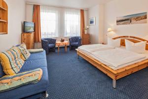 a hotel room with a bed and a couch at Pension Haus Antje in Ahlbeck