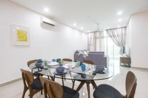 a dining room with a glass table and chairs at 1Medini Condo By JBLOKA in Nusajaya