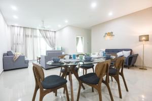 a dining room and living room with a table and chairs at 1Medini Condo By JBLOKA in Nusajaya