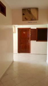 a room with a wooden door and a television at HOTEL BEACH CLUB LEGZIRA in Sidi Ifni
