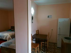 a small kitchen with a table and a refrigerator at Guest House Villa in Kvareli