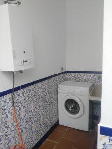 a washing machine in a laundry room with a wall at La casa del viajero in Ardales