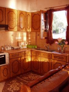 a kitchen with wooden cabinets and a sink and a window at Elpidas Holiday House in Kardamyli