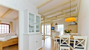 Una cocina y un comedor con mesa y sillas. en Villa Bellevue, en Ahlbeck