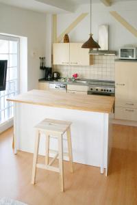 cocina con encimera, mesa y taburete en Villa Bellevue, en Ahlbeck