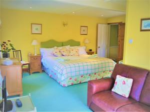 a bedroom with a bed and a couch and a chair at Rectory Farm in Levisham