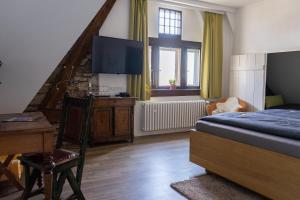 a bedroom with a bed and a staircase with a television at Altes Amtsgericht Oppenheim in Oppenheim