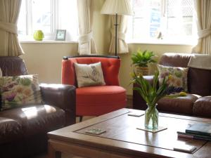 sala de estar con 2 sillas de cuero y mesa en Rectory Farm en Levisham