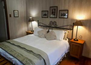 ein Schlafzimmer mit einem großen weißen Bett mit zwei Lampen in der Unterkunft The Pennefather in Haenertsburg