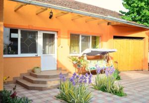 an orange house with a patio with an umbrella at Затишні Апартаменти Берегове in Berehove +2 photos