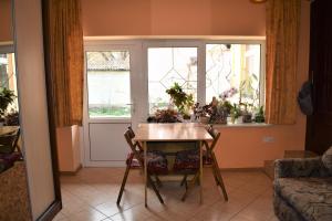 a dining room with a table and two windows at Затишні Апартаменти Берегове in Berehove