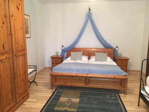 イルミッツにあるSekt & Wein - Walter Kleinのベッドルーム1室(青い天蓋付きのベッド1台付)