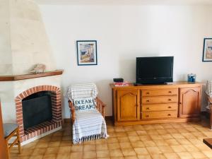 a living room with a tv and a fireplace at Casa 3 dormitorios Cala Galdana in Cala Galdana