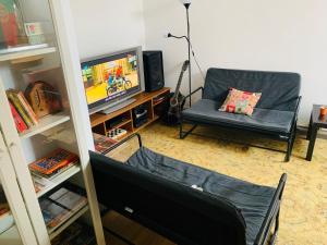 a living room filled with furniture and a tv at M2Students Hostel in Porto