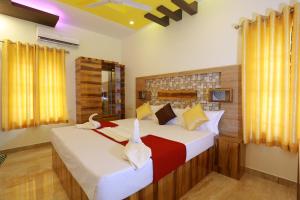 two beds in a bedroom with two swans on them at Dayout Regency in Alleppey