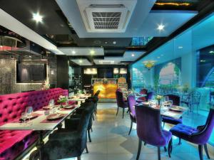 a dining room with tables and purple chairs at Aspira Skyy Sukhumvit 1 in Bangkok
