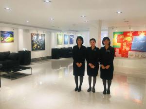 a group of three women standing in a lobby at K.C Hotel in Yangon