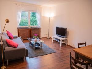a living room with a couch and a tv at Messe-Apartment in Essen