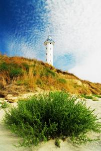 a white lighthouse sitting on top of a hill at Marina Cape Vacation Complex in Ravda