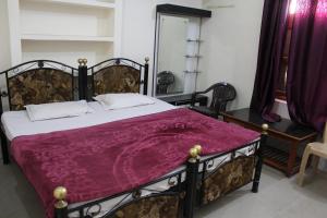 una camera da letto con un grande letto con una coperta viola di Best B&B in Orchha a Orchha