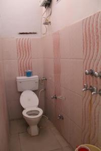 a small bathroom with a toilet and a shower at Best B&B in Orchha in Orchha