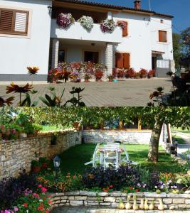 a house with a table and flowers in the yard at Apartment Milan Istra in Režanci
