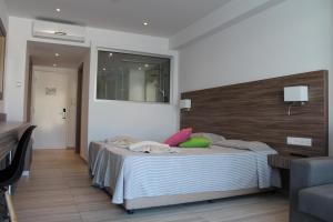 a bedroom with a bed with a wooden head board at Fedrania Gardens Hotel in Ayia Napa