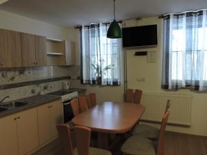 a kitchen with a wooden table and a dining room at Apartments Gubanec in Cerklje na Gorenjskem