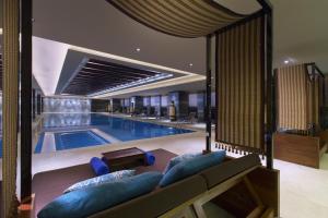 a large swimming pool with blue furniture in a hotel at Wanda Vista Taiyuan in Taiyuan