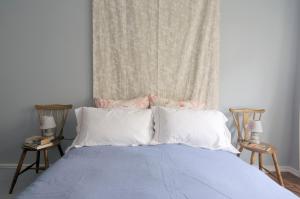 a bed with blue sheets and white pillows in a bedroom at Gulbenkian Gardens in Lisbon