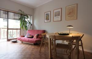 a living room with a table and a pink couch at Gulbenkian Gardens in Lisbon