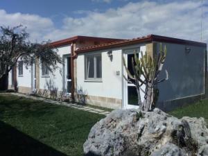 een huis met een rots ervoor bij La casetta di viale Paradiso in Pachino