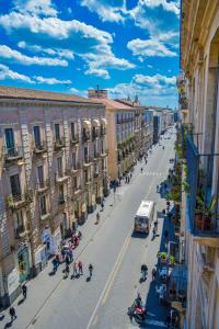 a city street with buildings and people walking on the street at The Artist's Home Catania Centro in Catania