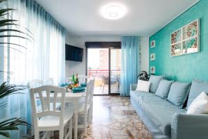 a living room with a blue couch and a table at Apartamento AGUA MARINA Levante Beach in Benidorm
