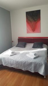 een slaapkamer met een bed met twee handdoeken erop bij Homestay Dodo in Lugano