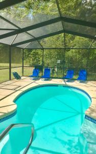 a swimming pool with chairs and an umbrella at PRIVATE Log Cabin with Indoor pool sauna and gym YOU RENT IT ALL NO ONE ELSE in McAlpin