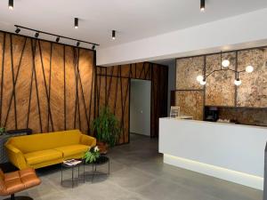 eine Lobby mit einem gelben Sofa und einem Tresen in der Unterkunft Casa Boca- free parking in Cluj-Napoca