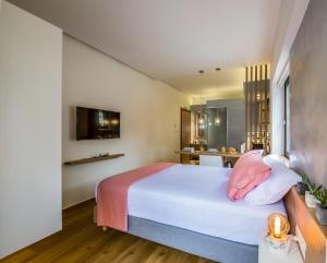 a bedroom with a large white bed with pink pillows at Nest of Marmel Luxury Studio in Chania