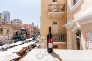 una bottiglia di vino seduta su un tavolo con un bicchiere di House of Palm - One of a Kind a Tel Aviv