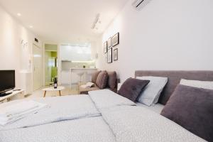 a white bedroom with a bed and a couch at Apartment Hana Lux in Belgrade
