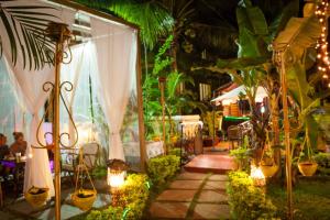 een tuin met een tafel, stoelen en planten bij Shivers Oasis Luxury Boutique Resort in Candolim