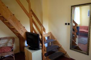 a room with a staircase with a television and a mirror at Apartmán Marta in Staré Splavy