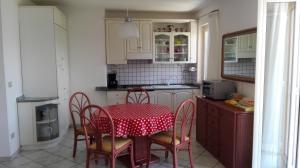 une cuisine avec une table et des chaises ainsi qu'une nappe rouge et blanche dans l'établissement Panorama sul lago, à Porto Valtravaglia 18 autres photos