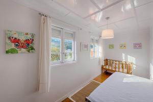 een witte kamer met een bed en een raam bij Casa da Real Companhia in Lamego