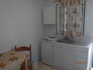 a small kitchen with a sink and a table at Mylos Garden in Livadi