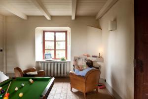a man sitting in a chair next to a pool table at Castello Di San Sebastiano Po in Chivasso