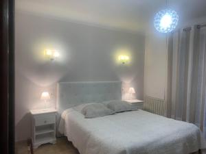 a bedroom with a white bed and two night stands at Coatmeur brunette jean marie in Cabasse +43 photos